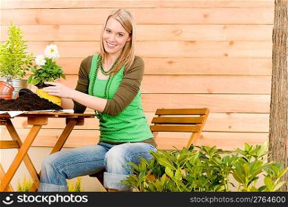 Gardening woman planting spring flower on terrace