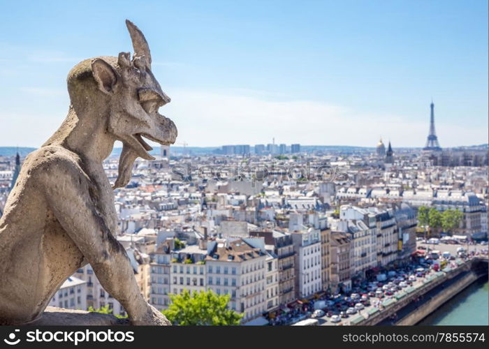 Gargoyle Stryge and demon at Notre Dame of Paris overlooking the skyline at a summer day (Selectice focus at Gargoyle)