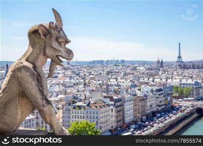 Gargoyle Stryge and demon at Notre Dame of Paris overlooking the skyline at a summer day (Selectice focus at Gargoyle)