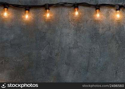 Garland of warm glowing edison glass l&s on rustic wall border 