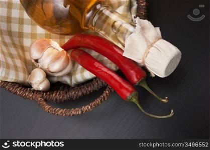 garlic and a basket with a bottle of vinegar