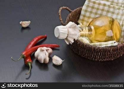 garlic and a basket with a bottle of vinegar