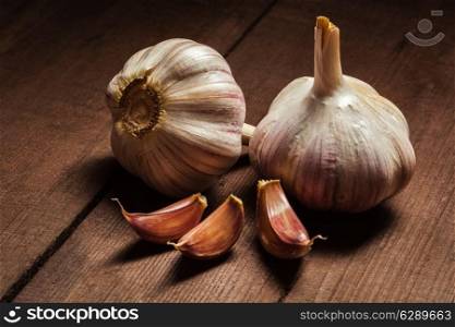 Garlic and cloves on old wooden background