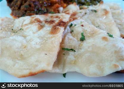 Garlic and coriander naan on a plate. Indian food.
