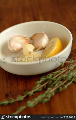 Garlic and lemon in a white bowl on table.