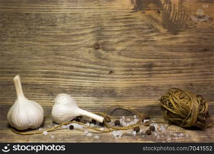 Garlic and spices on wooden background. Free space for text.