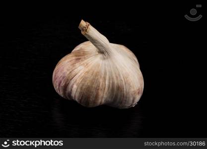 Garlic bulb closeup isolated on dark stone background