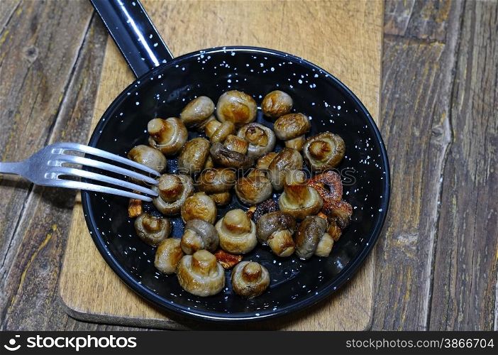 Garlic mushrooms in the pan on the kitchen table.
