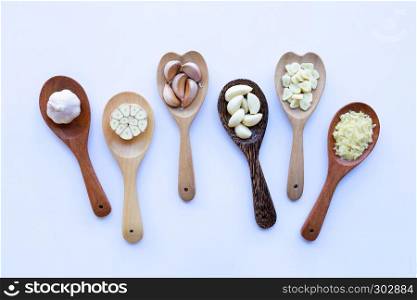 Garlic on wooden spoon on white background