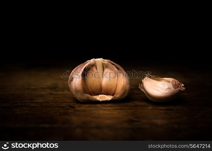Garlic on wooden surface and black background