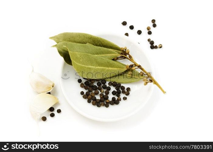garlic, peppercorn and bay leaf over white