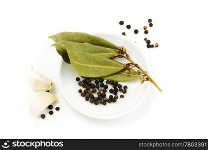 garlic, peppercorn and bay leaf over white