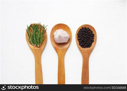 Garlic with rosemary and black peppercorn isolated on white.. Garlic with rosemary and black peppercorn isolated on white wooden background