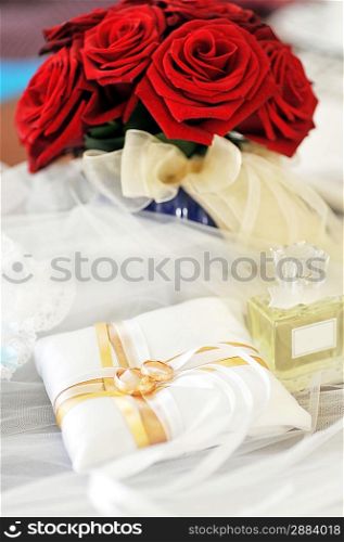 Garter, roses, perfume and wedding rings