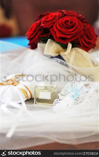 Garter, roses, perfume and wedding rings