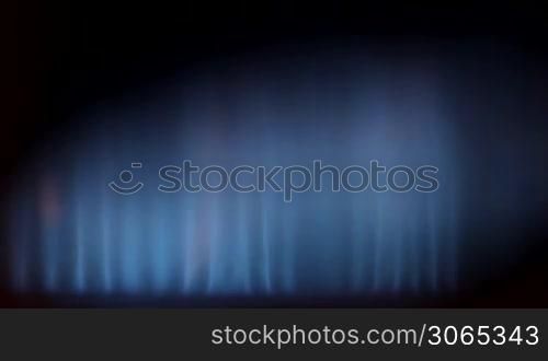 gas burning in some heating device, blue flame with yellow sparkling