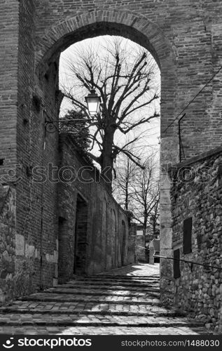 Gate and medieval street in Santarcangelo di Romagna town, Rimini Province, Italy. Black and white photography