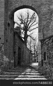 Gate and medieval street in Santarcangelo di Romagna town, Rimini Province, Italy. Black and white photography