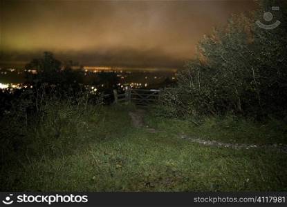 Gate at the end of a field, night time