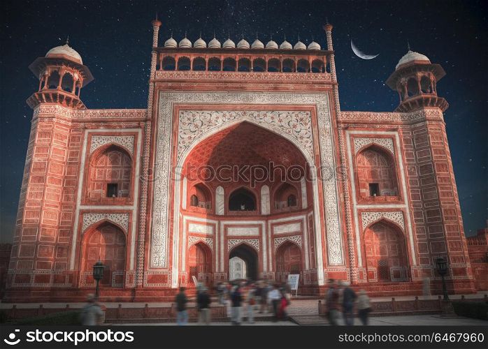gate through which the Taj Mahal . At night, under the stars and moon