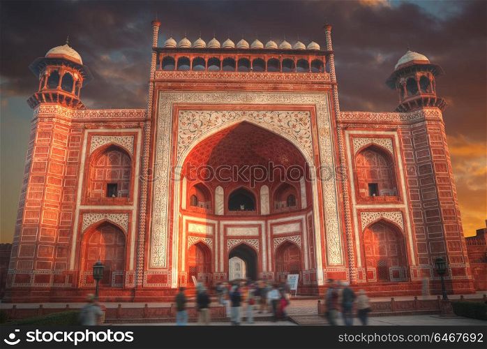 gate through which the Taj Mahal visitors in a park that surrounds the mausoleum