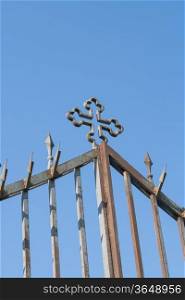 gate with cross from metal on blue air background