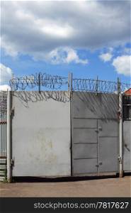 Gates with barbed wire and cloudy sky