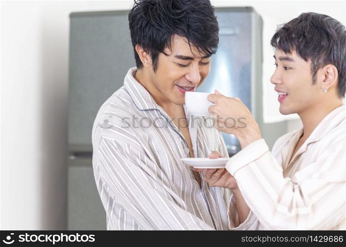 Gay couple homosexual cookking together in the kitchen make a breakfast relation fall in love. LGBTQ relation lifestyle concept.