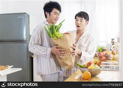 Gay couple homosexual cookking together in the kitchen make a breakfast relation fall in love. LGBTQ relation lifestyle concept.