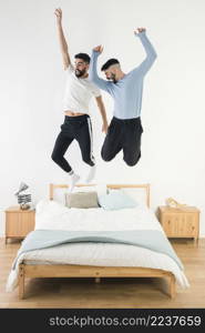 gay couple jumping bed bedroom