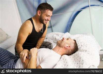 Gay couple tickling each other in bed. LGTB concept.. Gay couple tickling each other in bed