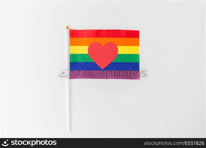 gay pride, homosexual and lgbt concept - red heart on rainbow flag over white background. red heart on rainbow flag over white background. red heart on rainbow flag over white background