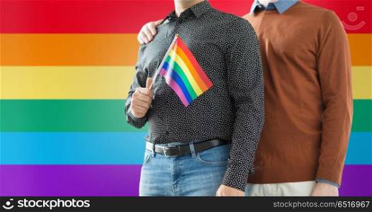 gay pride, lgbt and homosexual concept - close up of happy male couple with rainbow flag. close up of male couple with gay pride flag. close up of male couple with gay pride flag