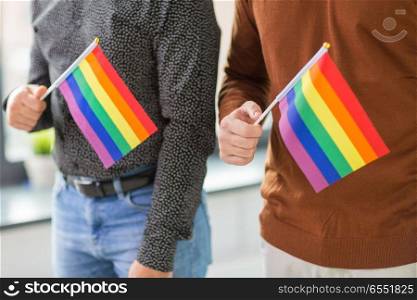 gay pride, lgbt and homosexual concept - close up of male couple with rainbow flags. close up of male couple with gay pride flags. close up of male couple with gay pride flags