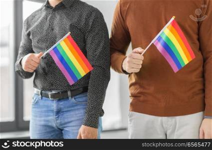 gay pride, lgbt and homosexual concept - close up of male couple with rainbow flags. close up of male couple with gay pride flags