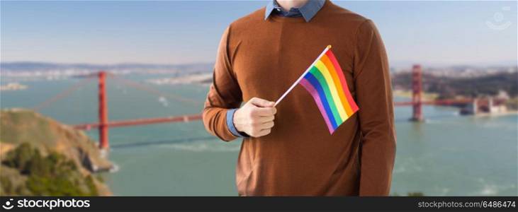 gay pride, lgbt and homosexual concept - close up of man with rainbow flag over golden gate bridge in san francisco bay background. close up of man with gay pride rainbow flag. close up of man with gay pride rainbow flag