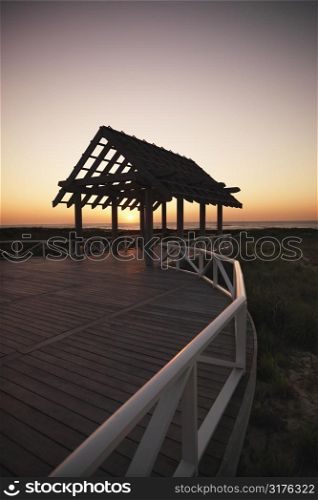 Gazebo at North Carolina coast with setting sun in background.