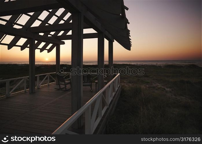 Gazebo at North Carolina coast with setting sun in background.