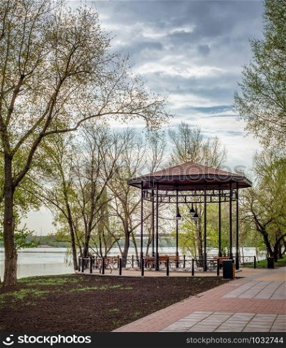 Gazebo with wooden benches, in the Naltalka park of Kiev, Ukraine, near the Dnieper river, during a cloudy spring morning