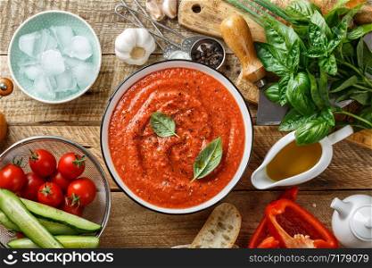 Gazpacho soup. Traditional spanish cold tomato soup of fresh raw vegetables with cooking ingredients on a wooden table top view