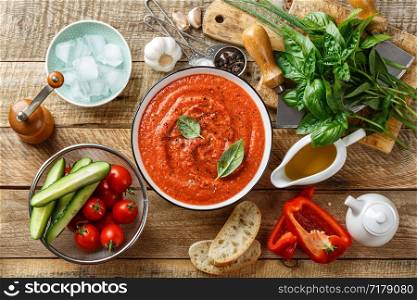 Gazpacho soup. Traditional spanish cold tomato soup of fresh raw vegetables with cooking ingredients on a wooden table top view