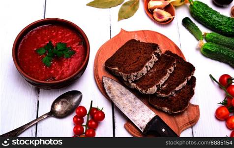 Gazpacho spanish cold soup in a round ceramic plate and bread, top view