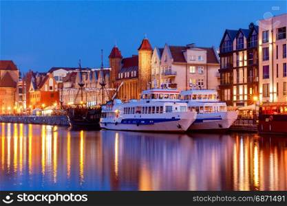 Gdansk. Central embankment at night.. Multi-colored facades and boat on the central waterfront in Gdansk at night.
