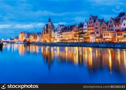 Gdansk. Central embankment at night.. Multi-colored facades and boat on the central waterfront in Gdansk at night.