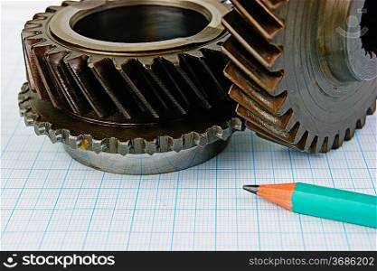 Gear and pencil on graph paper