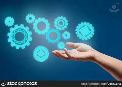 gear wheels and female hand on a blue background. Business structure precise work concept, team unification