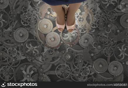 Gears as teamwork concept. Top view of businesswoman standing on floor of gears