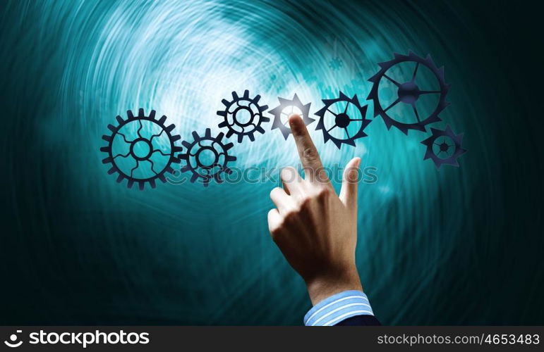 Gears mechanism. Close up human hand pointing with finger at gears mechanism