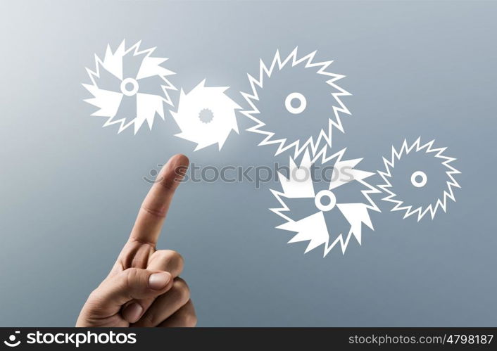 Gears mechanism. Close up human hand pointing with finger at gears mechanism