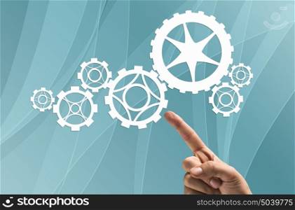 Gears mechanism. Close up human hand pointing with finger at gears mechanism
